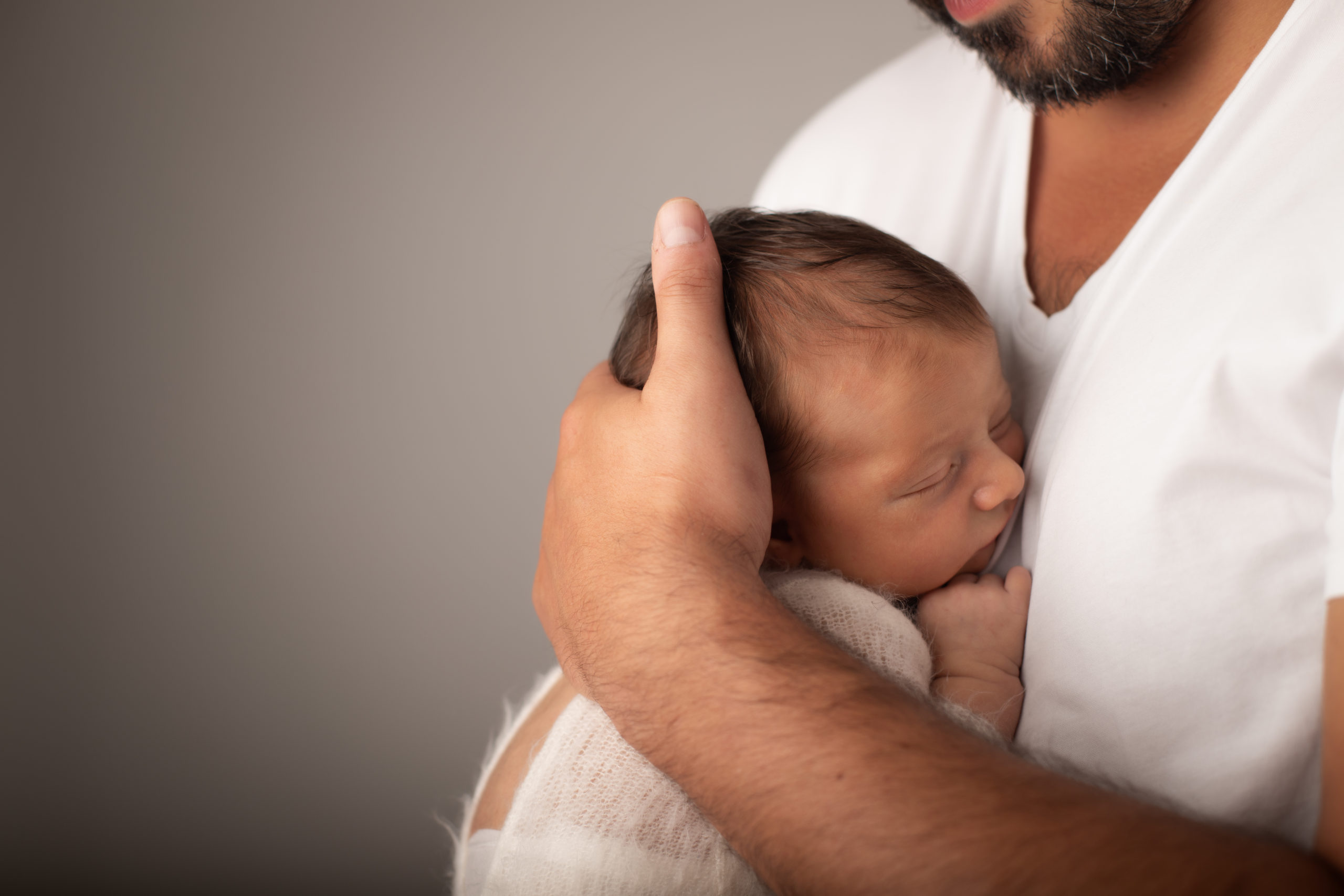 Photographe nouveau-né, bébé moins de 15 jours, newborn dans les bras de son papa de sa maman parent, séance naissance mise en scène, studio photo 31.